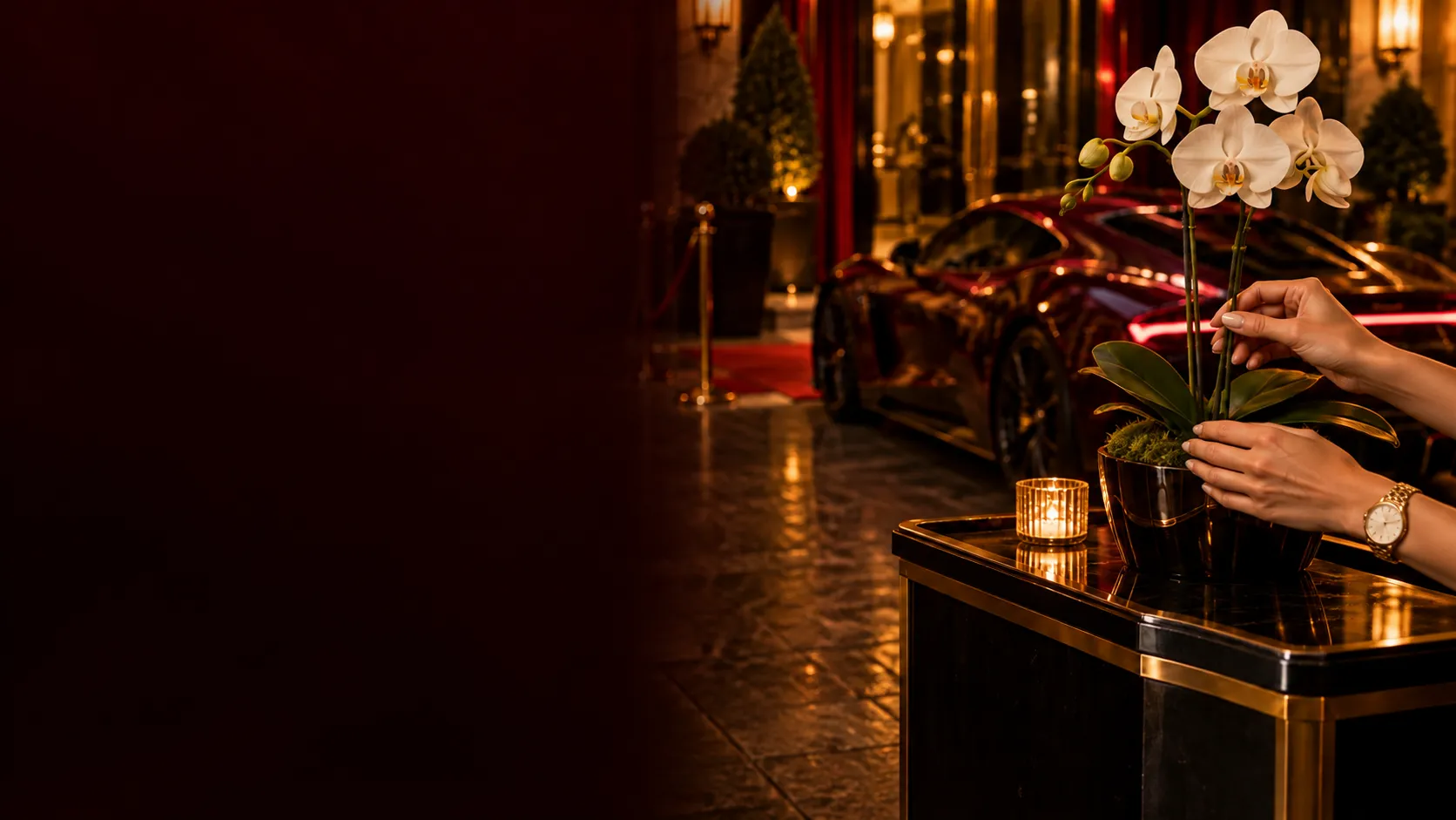 Hands calmly arranging a white orchid beside a parked supercar, a composed moment away from the tables